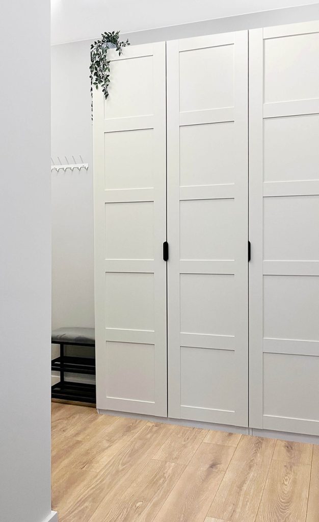 Przestronny przedpokój z dużą białą szafą i drewnianą podłogą, nowoczesne wykończenie - mieszkanie 3 -pokojowe, Łódź