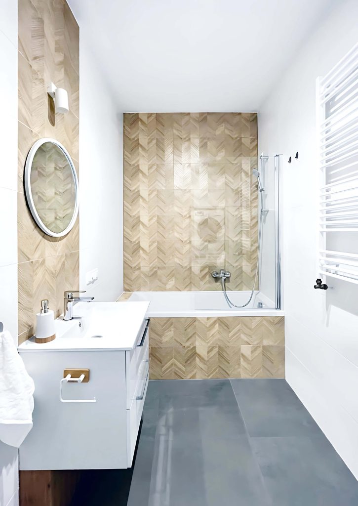 Nowoczesna łazienka z wanną i szklanym parawanem, białą szafką z i białą umywalką - mieszkanie na wynajem Łódź