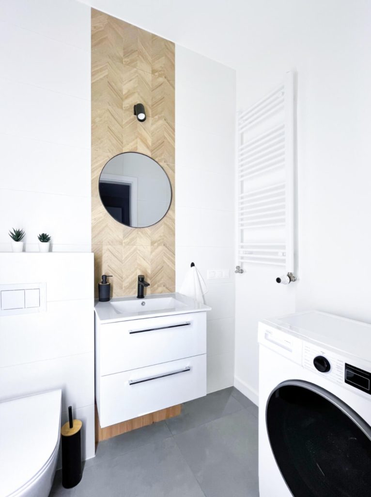 Nowoczesna łazienka z podwieszaną białą szafką i umywalką, pralka, kaloryfer drabinkowy - mieszkanie 2 pokojowe na wynajem Łódź, Pomorska 107a