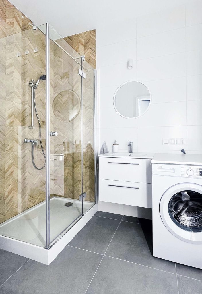 Jasna łazienka z prysznicem typu walk-in, białą umywalką z szafką, pralką i okrągłym lustrem - cześć wspólna w mieszkaniu na wynajem Łódź, Śródmieście